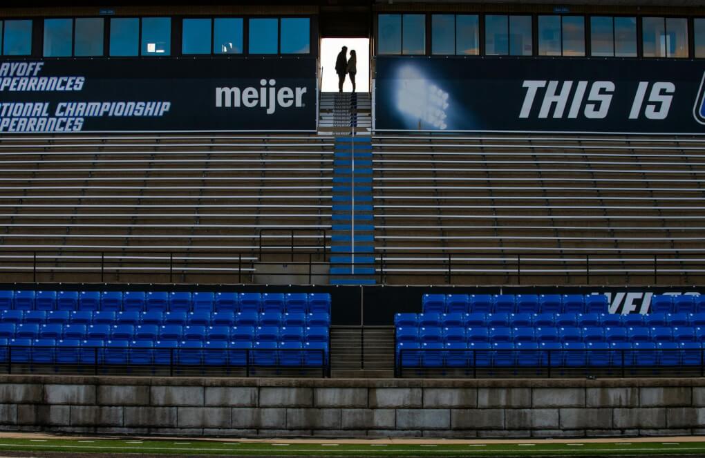 A couple embraces at the top of the bleachers at Lubbers Stadium